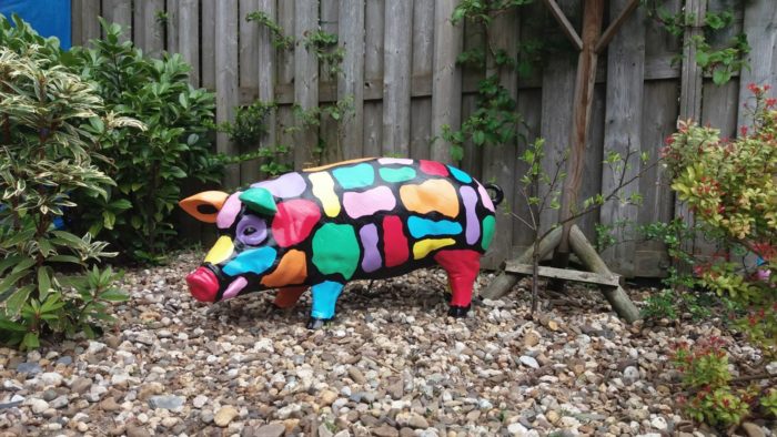 polyester beeld van een beschilderd varken als kunstobject in de tuin
