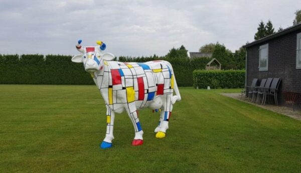 Vrolijke beelden Een levensgrote koe beschilderd in Piet Mondriaan kleuren en motieven