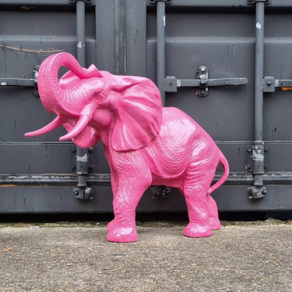 tuinbeeld van een roze olifant met de slurf omhoog