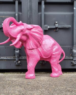 tuinbeeld van een roze olifant met de slurf omhoog