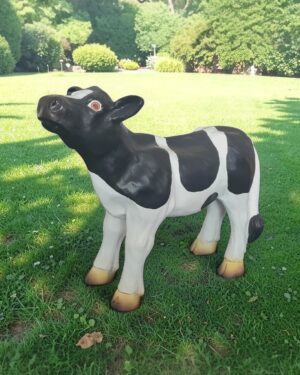 Polyester zwartbont kalfje in een mooie zonnige tuin