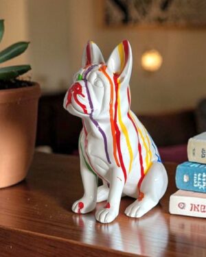 Wit bulldog beeldje met kleurrijke regenboog drip verf op tafel